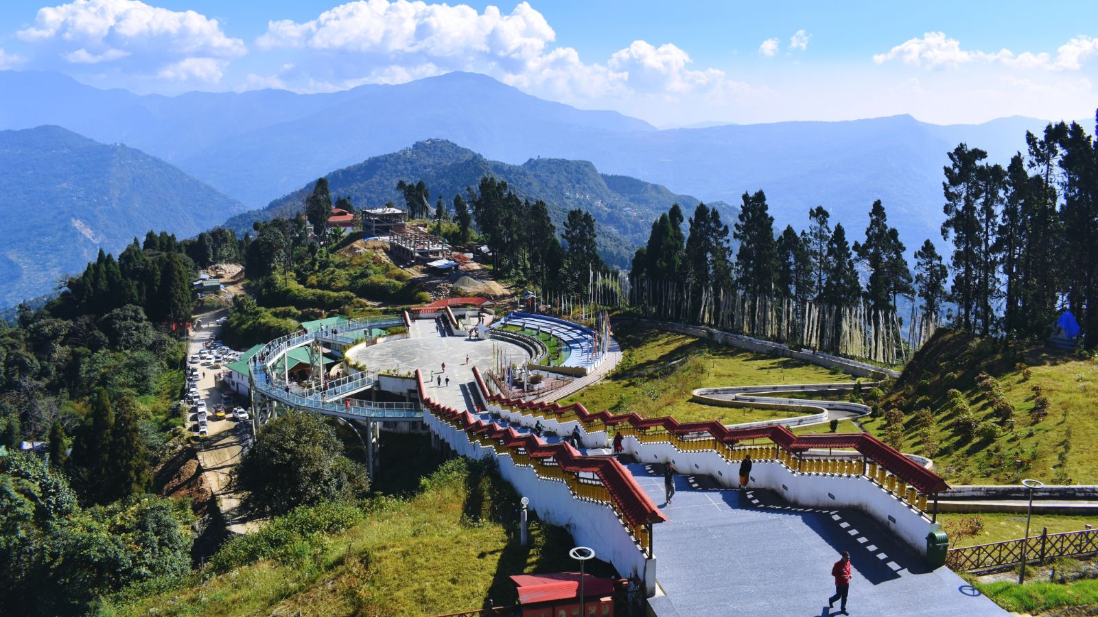 Pelling hilltop viewpoint with terraces, pathway, and layered mountain ranges